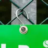 A close-up photo of a tennis racket with a yellow grip and strings, resting on a tennis court.