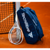 A tennis player hitting a powerful backhand shot during a match.